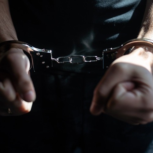 man in handcuffs on a black background