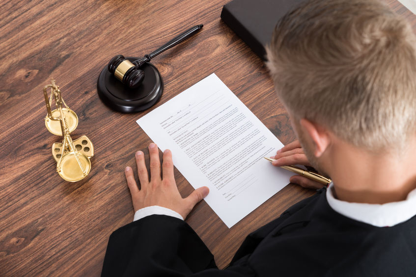 A Picture of a Judge Writing On a Paper in a Courtroom.